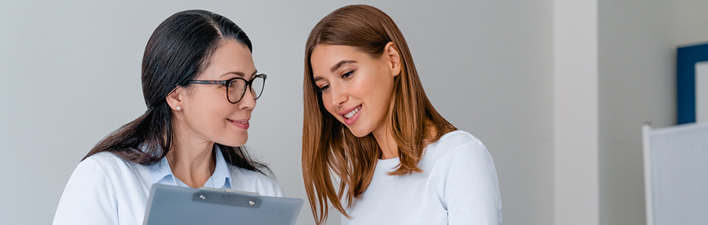 Doctor showing a clipboard to a female patient