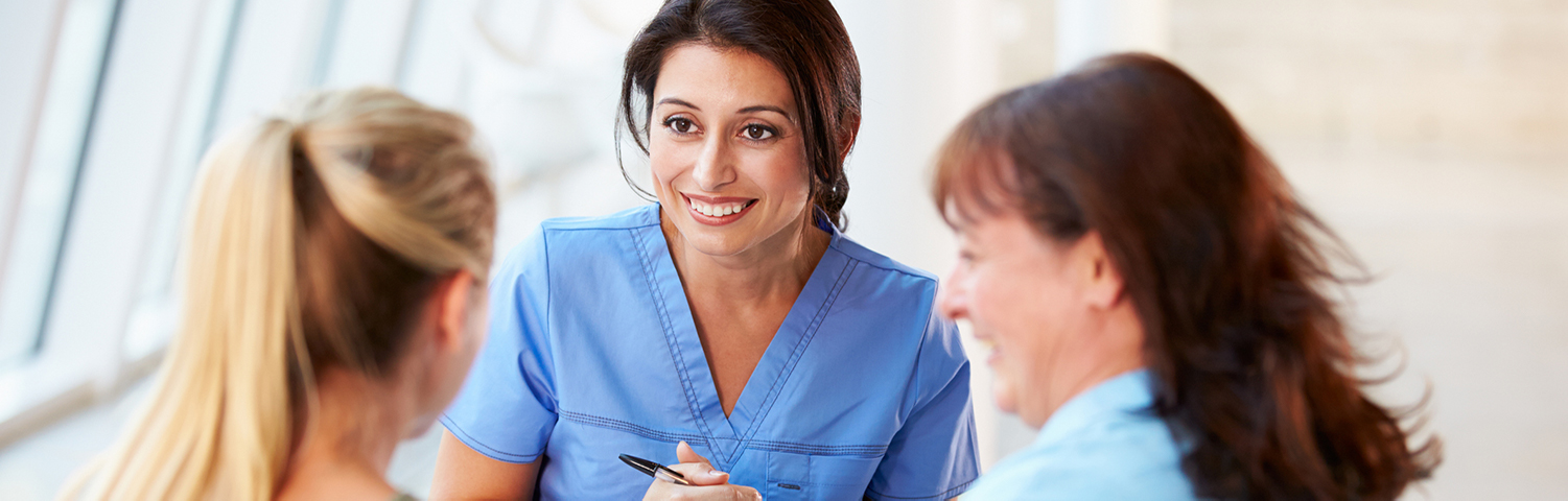 Nurse talking to teenage patient and guardian