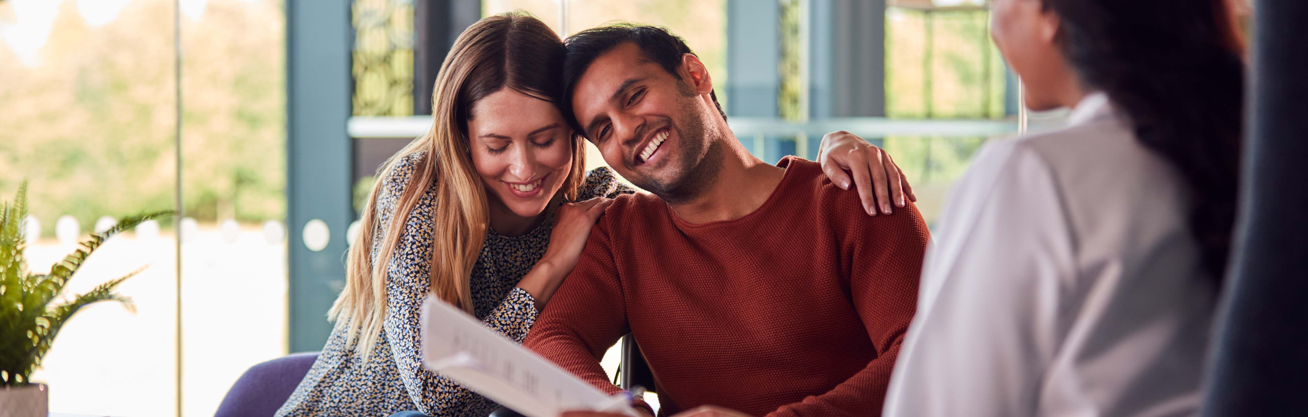 Couple speaking with a doctor looking at a report