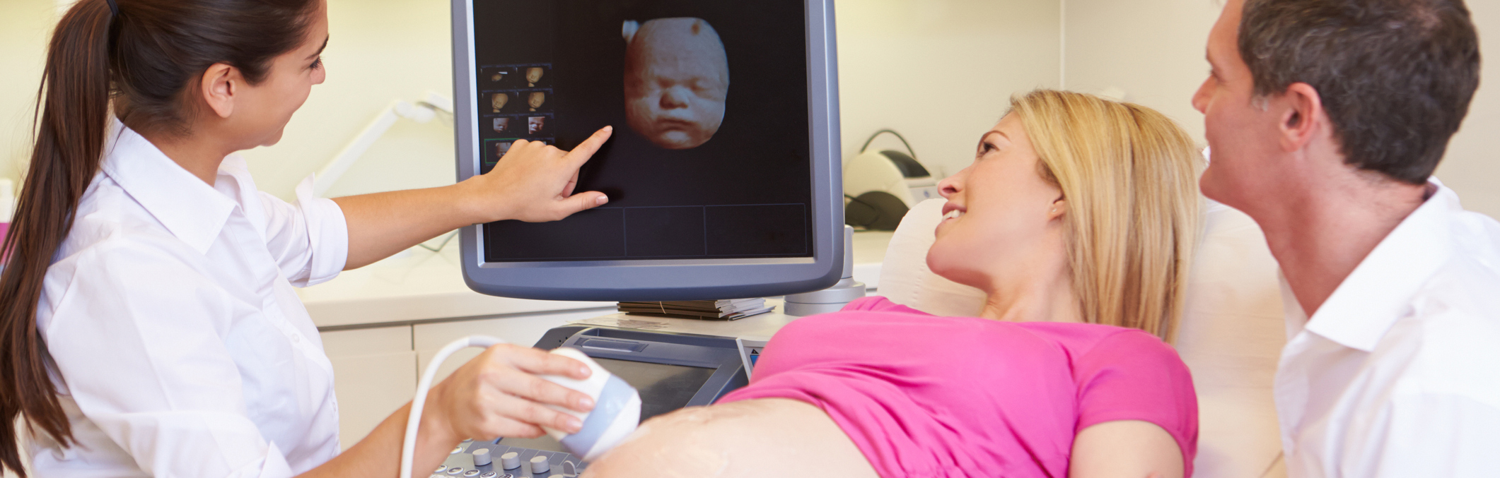 Happy couple looking at ultrasound with medical professional