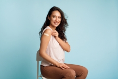 Happy Lady Showing Vaccinated Arm With Adhesive Bandage